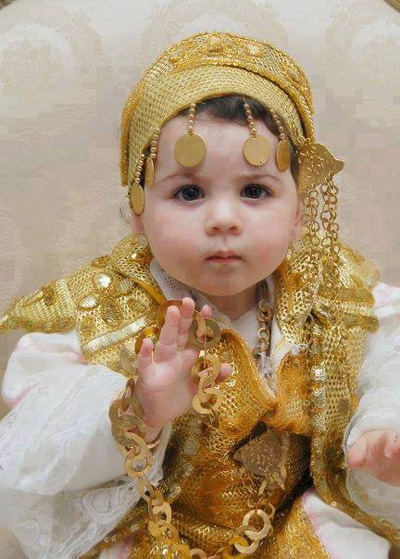 Little girl in festive clothing and with gold jewelry