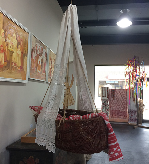 Willow crib with embroidered towels and straw doll amulet
