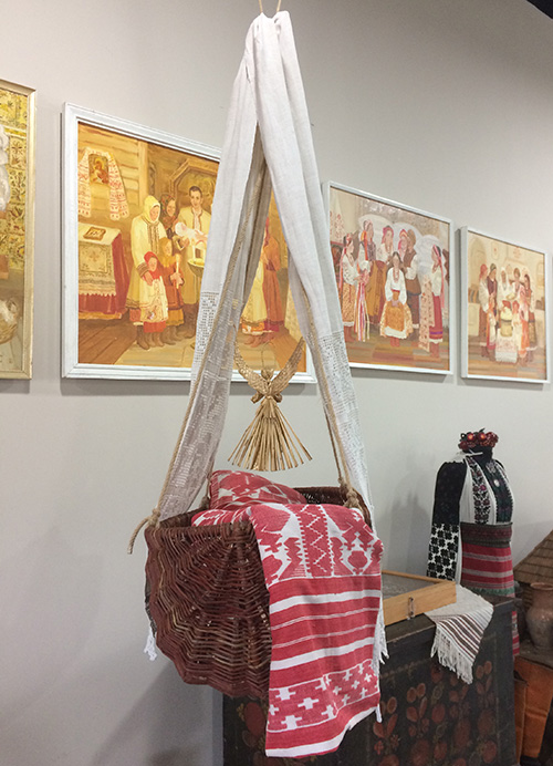 Willow crib with embroidered towels and straw doll amulet