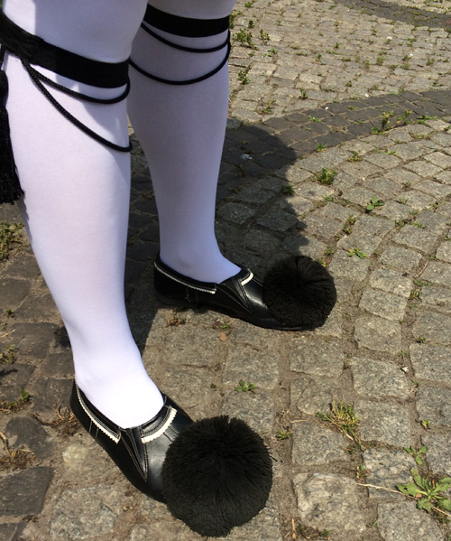 Greek traditional tsarouchia shoes with large pom-poms