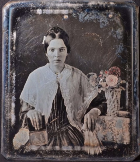 Woman holding Daguerreotype portrait late 1840s