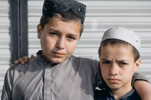 Boys in Pakistani topi caps – Sindhi topi on the left and Muslim white topi on the right
