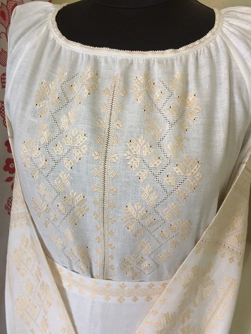 Very delicate modern women’s outfit embellished with peach-color embroidery