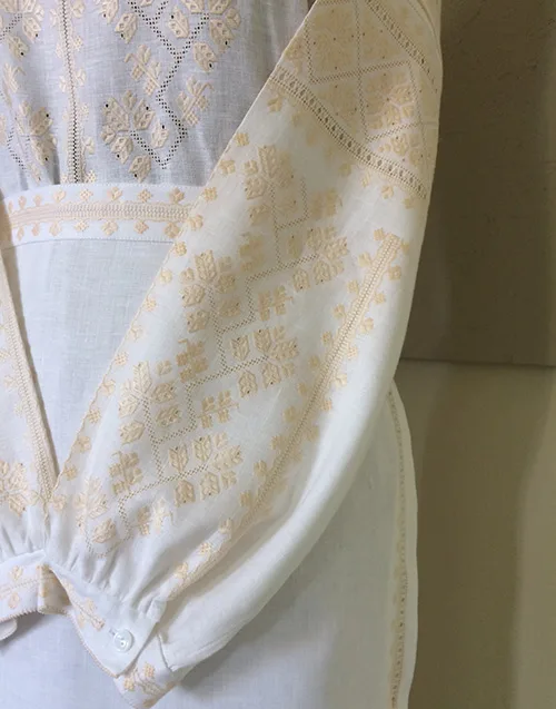 Very delicate modern women’s outfit embellished with peach-color embroidery